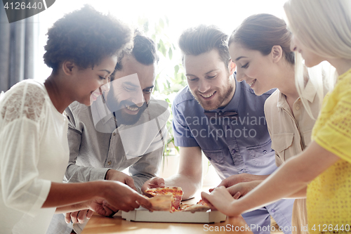 Image of happy business team eating pizza in office