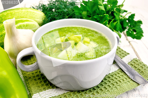 Image of Soup cucumber with peppers in white bowl on board