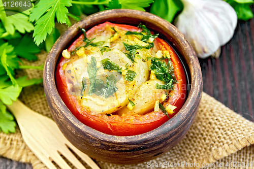 Image of Fish baked with tomato and garlic in clay bowl on board