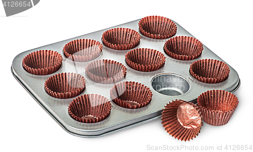 Image of Cupcake and muffin pan with paper cups some beside