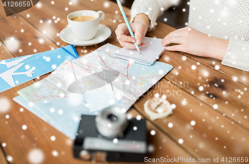 Image of close up of traveler hands with notepad and pencil