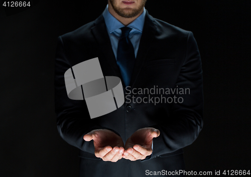 Image of close up of businessman holding something in hands