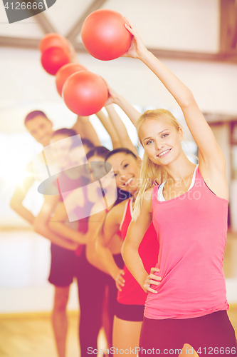 Image of group of smiling people working out with ball