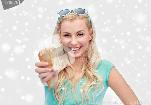 Image of happy young woman in sunglasses eating ice cream