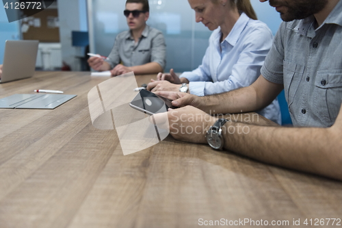 Image of close up of  businessman hands  using tablet on meeting