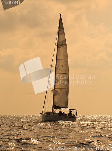 Image of Yacht sailing against sunset