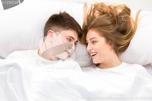 Image of The young lovely couple lying in a bed