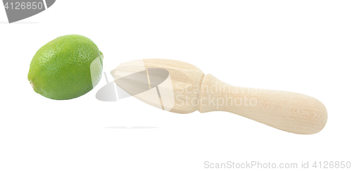 Image of Whole lime and wooden citrus reamer