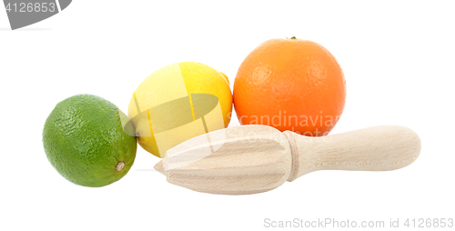 Image of Lime, lemon and orange fruit with wooden citrus reamer