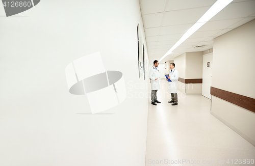 Image of male doctors talking at hospital corridor