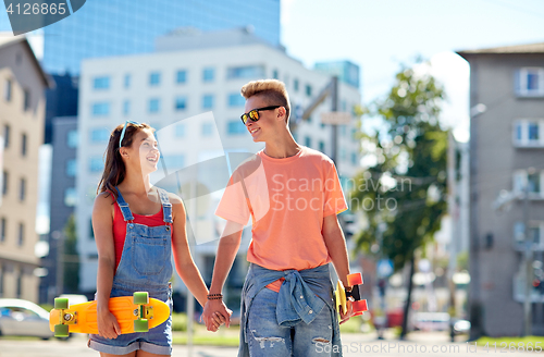 Image of teenage couple with skateboards on city street