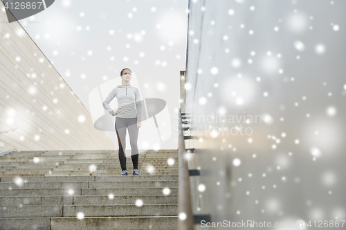 Image of sporty woman standing on in city stairs