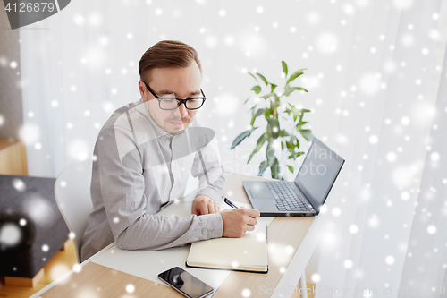 Image of creative man or businessman writing to notebook