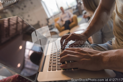 Image of close up of male hands while working on laptop