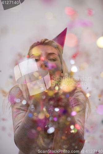 Image of woman blowing confetti in the air