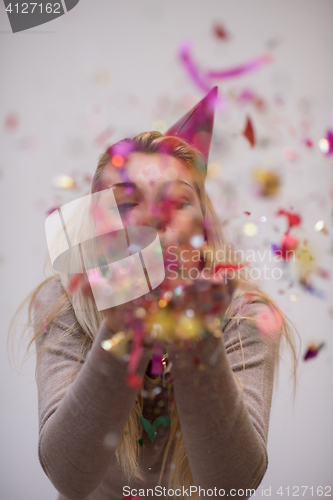 Image of woman blowing confetti in the air