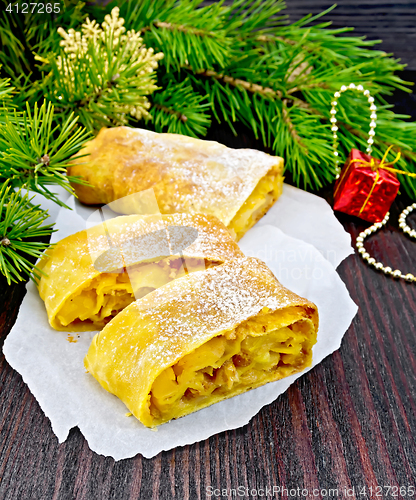 Image of Strudel pumpkin and apple with pine branches on board