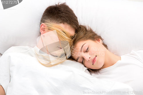 Image of The young lovely couple lying in a bed