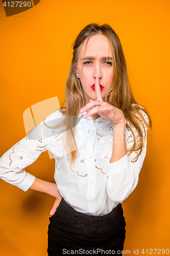 Image of The serious frustrated young beautiful business woman on orange background