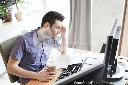 Image of creative male worker with computer drinking coffee