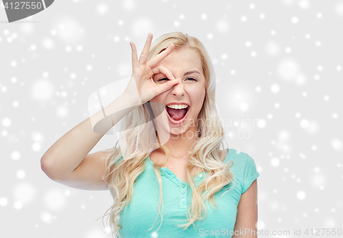 Image of young woman making ok hand gesture