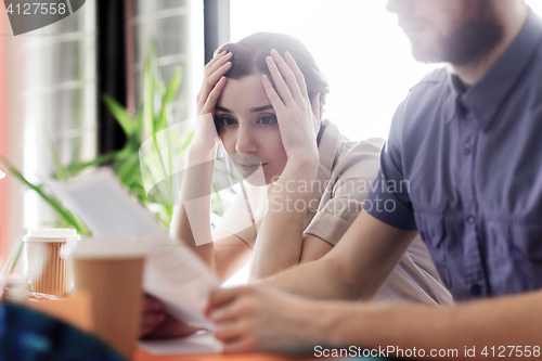 Image of creative team with reading paper in office