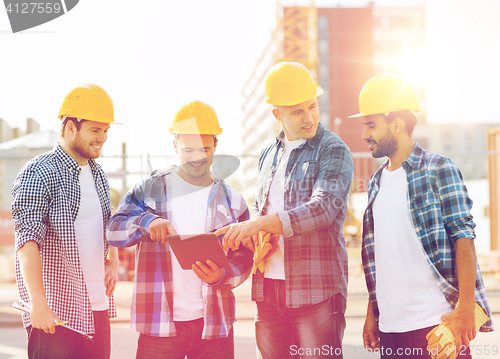 Image of group of smiling builders with tablet pc outdoors