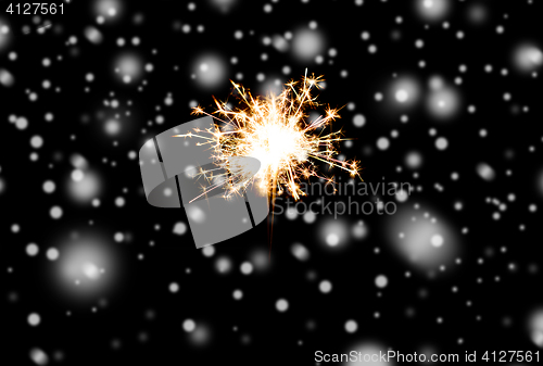 Image of sparkler or bengal light burning over black