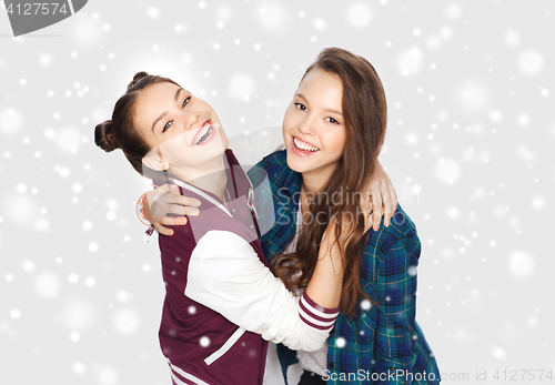 Image of happy smiling teenage girls hugging over snow