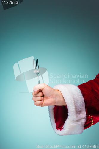 Image of The Santa hand holding a fork