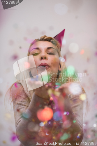 Image of woman blowing confetti in the air