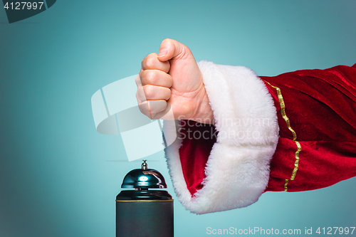 Image of Hand of Santa Claus pressing on the bell
