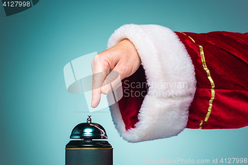 Image of Hand of Santa Claus pressing on the bell