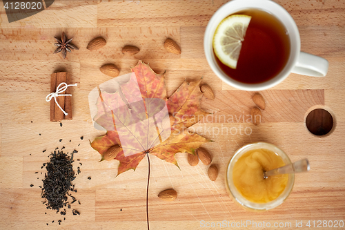 Image of cup of lemon tea and honey on wooden board