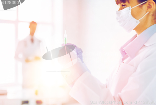 Image of female doctor holding syringe with injection