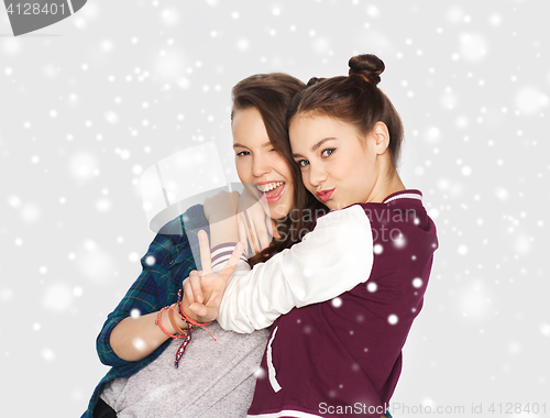 Image of happy teenage girls hugging and showing peace sign