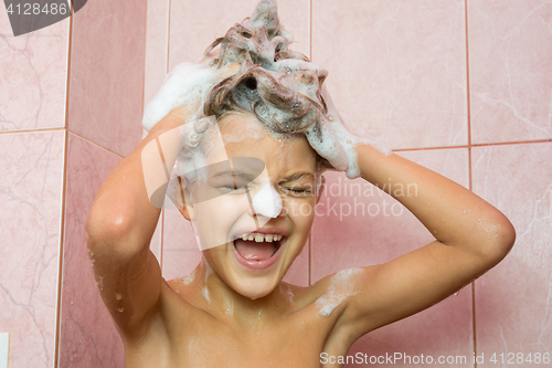 Image of Funny girl washing her hair with shampoo