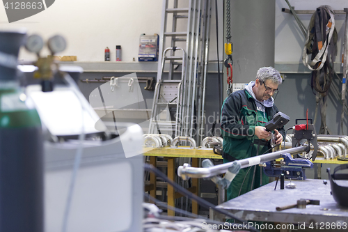 Image of Industrial worker setting orbital welding machine.