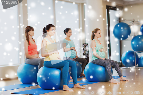Image of happy pregnant women with exercise balls in gym