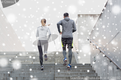 Image of couple of sportsmen running upstairs outdoors