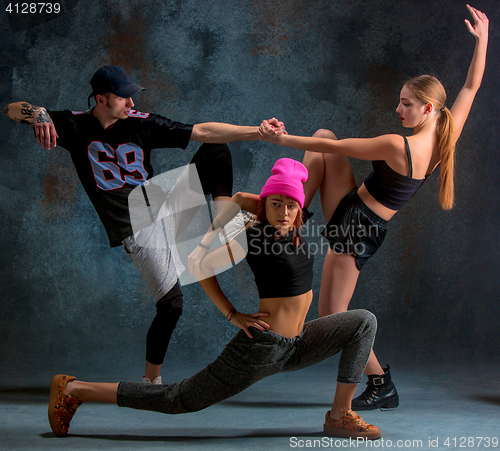 Image of The two young girsl and boy dancing hip hop in the studio