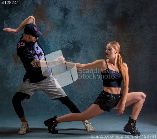 Image of The two young girl and boy dancing hip hop in the studio