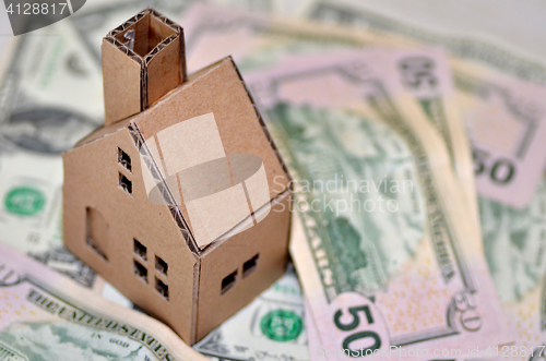 Image of Miniature paper made house stand on  money