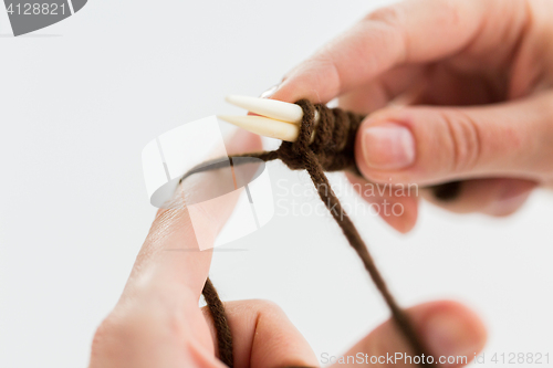 Image of close up of hands knitting with needles and yarn