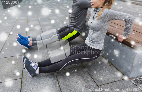 Image of couple of sportsmen doing triceps dip on bench