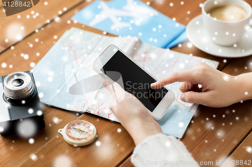 Image of close up of traveler hands with smartphone and map