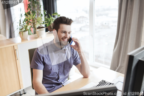 Image of happy creative male worker calling on smarphone