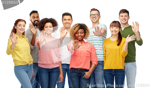 Image of international group of happy people waving hand