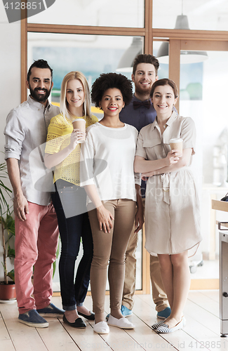 Image of happy smiling creative team with coffee in office