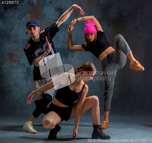 Image of The two young girsl and boy dancing hip hop in the studio